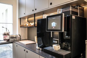 A coffee machine with a digital display, a coffee cup, and a jar of Nutella on a counter. - Hotel Alex an der Ahr (Bad Neuenahr-Ahrweiler)