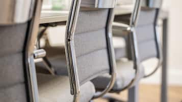 A row of office chairs with metal frames and grey upholstery.