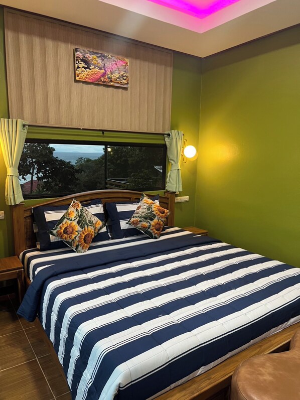 Ein Schlafzimmer mit Bett, Vorhängen, einer Uhr und einem Fenster mit Blick.