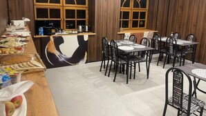 A restaurant with wooden panel walls, a buffet area with various food items, and multiple tables and chairs. - AIRIS RESIDENCE hotel (Almaty)