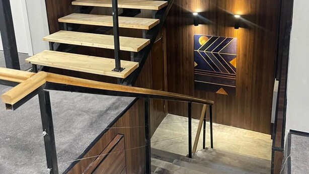 A modern staircase with wooden steps and metal railings, leading to a lower level. - AIRIS RESIDENCE hotel (Almaty)