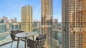 A high-rise building with a glass balcony, a round table, and two chairs. - Skyline Escape 2 bedroom with Burj Khalifa View (Business Bay)