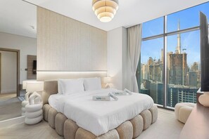 A modern hotel room with a large bed, a city view, and a unique wall design. - Skyline Escape 2 bedroom with Burj Khalifa View (Business Bay)