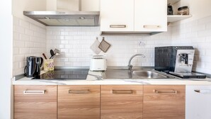 A modern kitchen with white cabinets, a stainless steel range hood, a coffee machine, and a toaster. - Holiday Home 'Debby' with Private Terrace, Wi-Fi and Air Conditioning (Otranto)