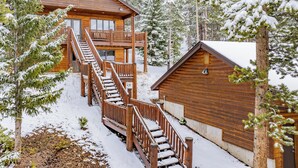 A wooden cabin with a staircase leading to a balcony, surrounded by snow-covered trees. - Spacious House with Excellent Ski Area Views (Breckenridge)