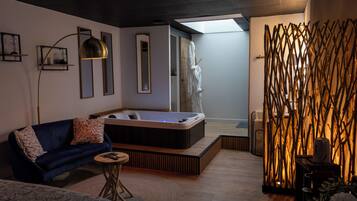 A modern room with a sofa, a small round table, a hot tub, and a decorative wall.