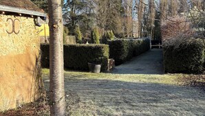 A pathway leading to a building with a stone facade and the number "00" visible. - Château de Posset - Les lofts (Teloché)