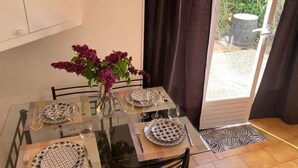 Una mesa de comedor dispuesta con platos, vasos y un jarrón de flores.
