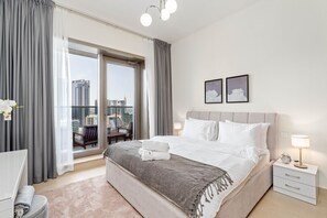 Een moderne hotelkamer met een groot bed, uitzicht op de stad en een balkon met een stoel.