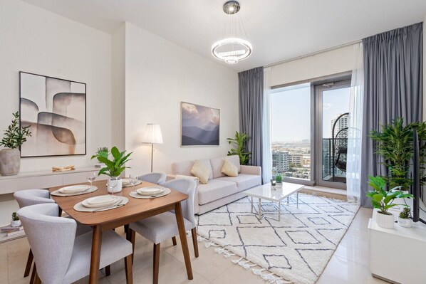 Een moderne woonkamer met een eethoek, grote ramen en stadszicht.