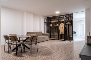 Una habitación moderna con una mesa de comedor, sillas, un sofá y un perchero.
