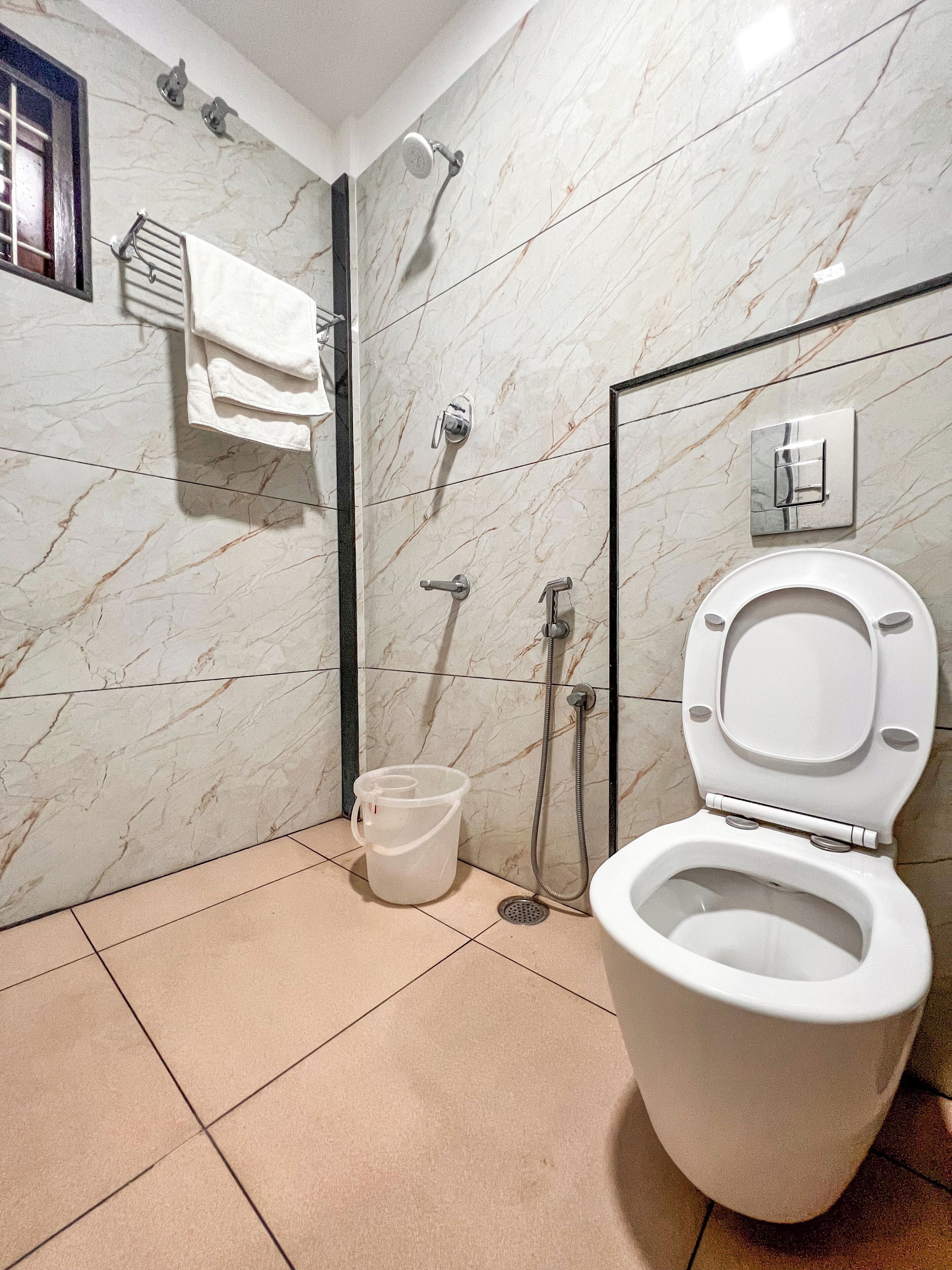 A bathroom with a toilet, a shower, and a sink.