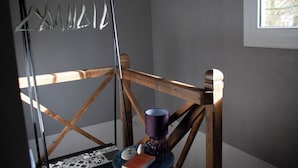 Une chaise en bois avec une structure en métal, une tasse violette et une petite assiette sur laquelle se trouvent un livre et un objet décoratif, le tout posé sur une table ronde.
