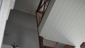 Un escalier en bois, avec un plafond blanc et un lustre.