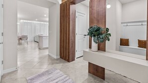 Et moderne interiør med en træreception, en potteplante og udsigt til et spiseområde.