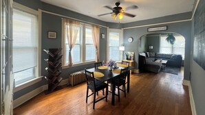 A dining area with a table, chairs, and a ceiling fan.