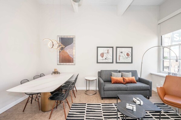 A modern living room with a dining table, sofa, and coffee table.