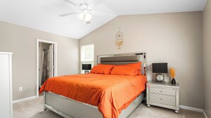 A bedroom with a bed, a nightstand, a ceiling fan, and a dreamcatcher on the wall. - 324 Beautiful Residence in Mebane NC. (Mebane)