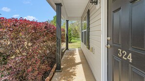 A covered porch with a dark door marked "324" and a light fixture above it. - 324 Beautiful Residence in Mebane NC. (Mebane)