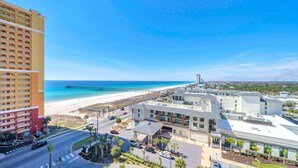 A coastal hotel with a beach view, a pier, and a parking area. - Calypso 3-1006 (Panama City Beach)