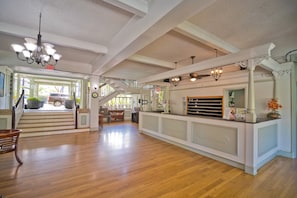 A spacious interior with a staircase, a reception desk, and a chandelier. - Ocean-view Condo – Private Lanai - In Kona Town (Kailua-Kona)