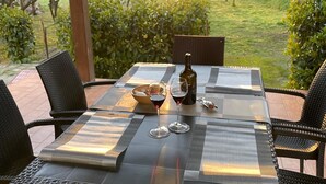 An outdoor patio with a table set for two, featuring a bottle and glasses. - Villa Gioia (Puglia)