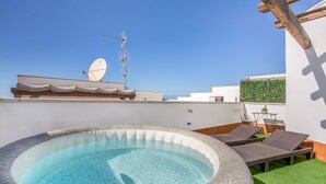 Une piscine sur le toit, dotée de chaises longues, d’une antenne parabolique et d’un mur végétal.