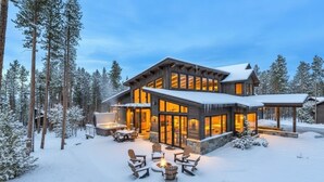 A modern log cabin with a large glass facade, outdoor seating, and a snow-covered landscape. - ✨ Soltierra • 🏔️ Breck Peak 8 • 🎿 Ski-In • 💦 10-Person Spa • 🛏️ 13 Beds (Breckenridge)