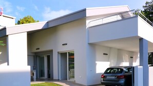 A modern building with a car parked in the driveway. - Stunning Villa With Private Fenced Garden and bbq (San Michele al Tagliamento)