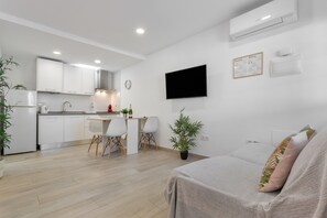 Un appartement moderne comprenant une cuisine, un coin repas et un salon.