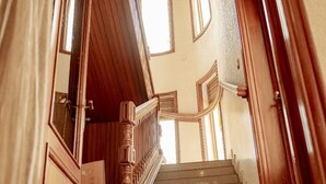Una escalera de madera con barandilla que da a una plataforma.