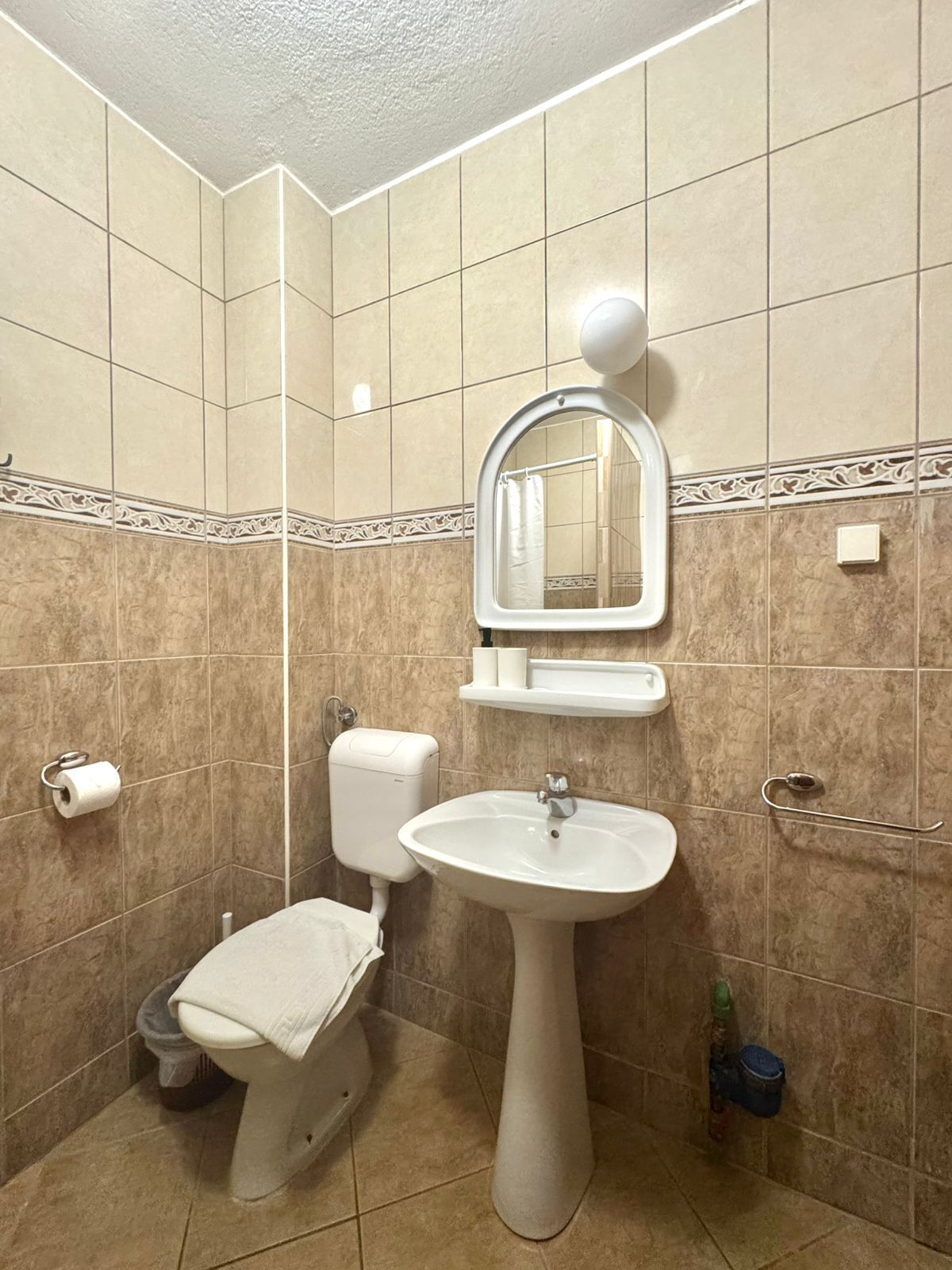 Un baño con inodoro, lavabo y espejo.