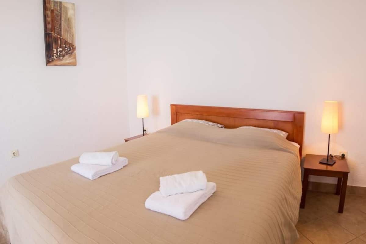 Une chambre d’hôtel avec un grand lit, deux lampes de chevet et un tableau au mur.