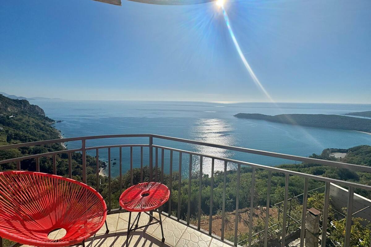 Un balcon offrant une vue dégagée sur la mer et le paysage lointain.