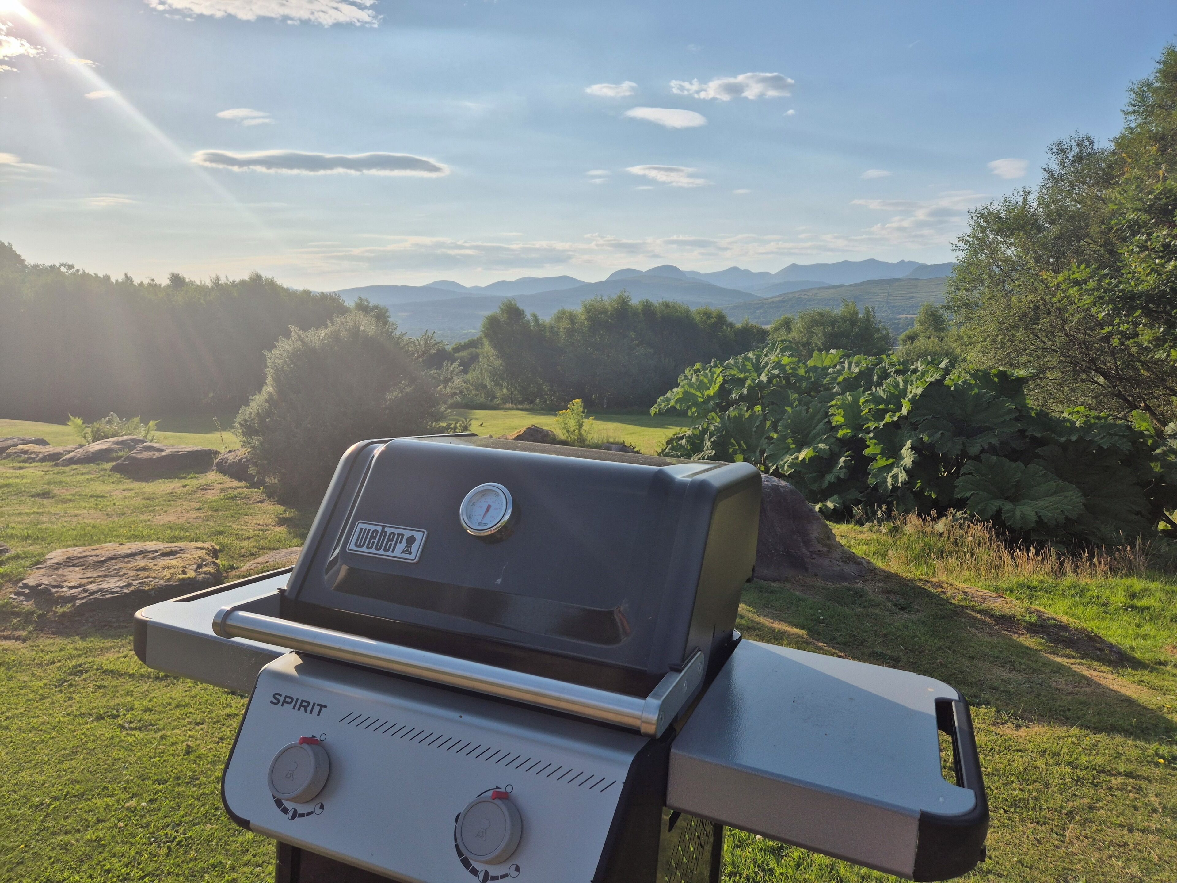 Una parrilla Weber Spirit con vistas a montañas al fondo.