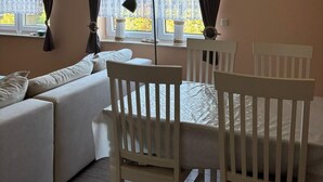Et hyggeligt værelse med en sofa, to stole, et bord og en lampe.