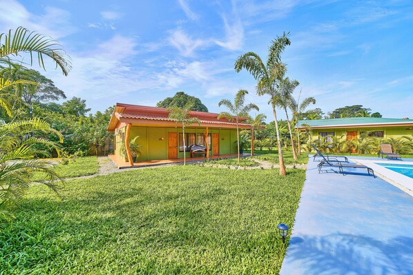 A house with a swimming pool, surrounded by lush greenery and palm trees. - Villas Ande (Puerto Viejo de Talamanca)