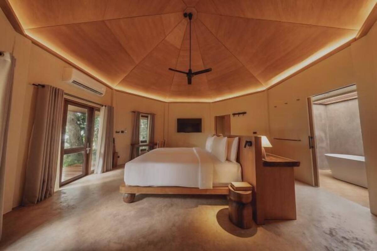 Un dormitorio con una cama grande, un escritorio y un ventilador de techo.