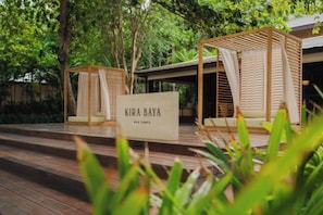 A wooden deck with a sign reading 'KIRA BAYA,' surrounded by lush greenery. - Kira Baya Koh Samed (Koh Samet)