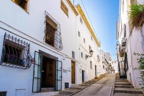 A narrow street lined with white buildings, each with a wooden door and metal window grilles. - Mira Altea - A Luxurious Boutique Stay (Altea)