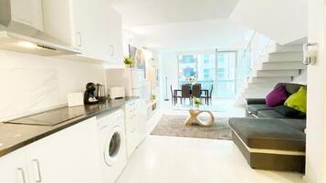 A modern apartment with a kitchen, dining area, and living room.