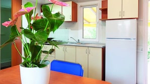 Eine Küche mit Spüle, Fenster und Kühlschrank.