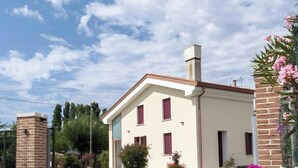 A two-story building with a brick chimney, a gated entrance, and a clear sky. - Mobile Home 'Casa Gerbera 6' with Private Garden and Wi-Fi (Cavallino-Treporti)