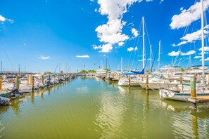 Un port de plaisance où sont amarrés de nombreux bateaux, avec une eau calme et un ciel dégagé.