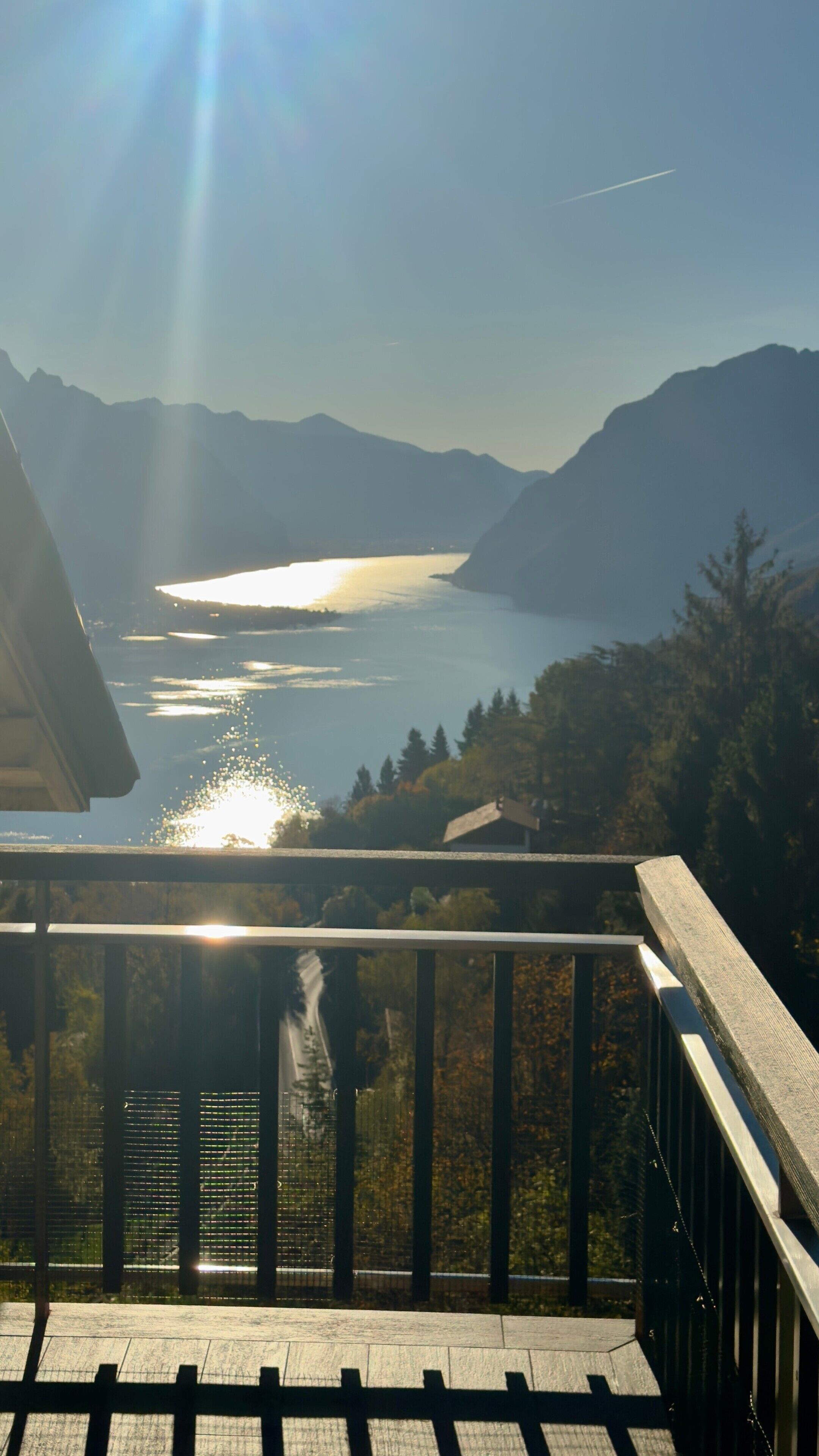 A balcony with a view of a lake and mountains.