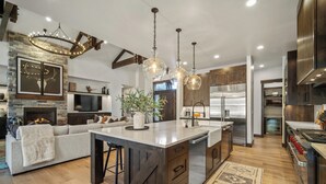 Una cocina moderna con una isla grande, electrodomésticos de acero inoxidable y una chimenea de estilo rústico.