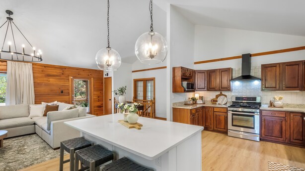 A modern kitchen with wooden cabinets, a large island, and stainless steel appliances. - Stay at Wild & Blue, Log Home Retreat, Game Room w/ Arcade (White Bluff)