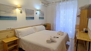 A neatly made bed with white linens, a wooden nightstand, a small table with a remote control, and two wall-mounted lamps. - Hostal Aliste (Madrid)