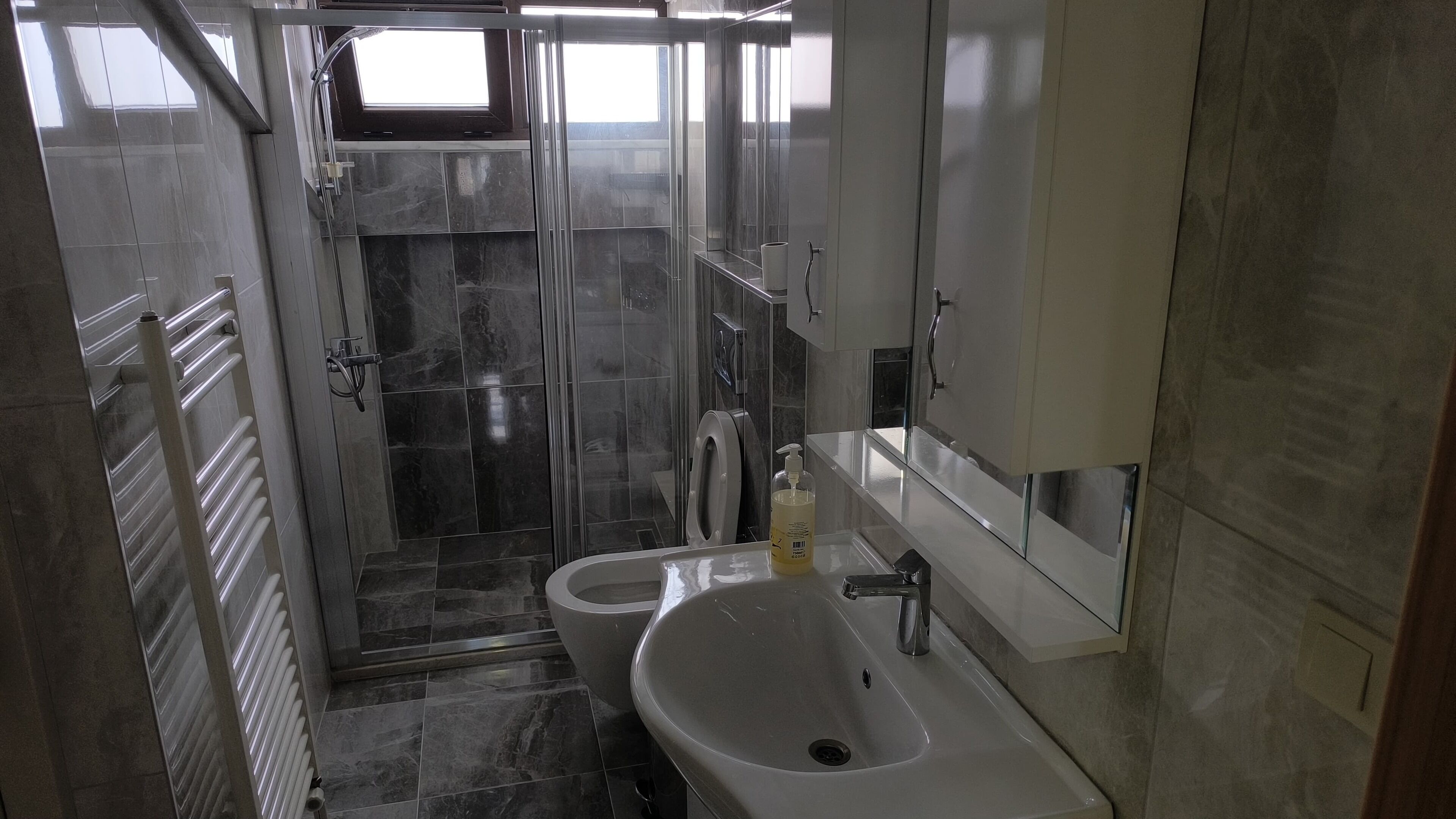 A bathroom with a shower, toilet, and sink.