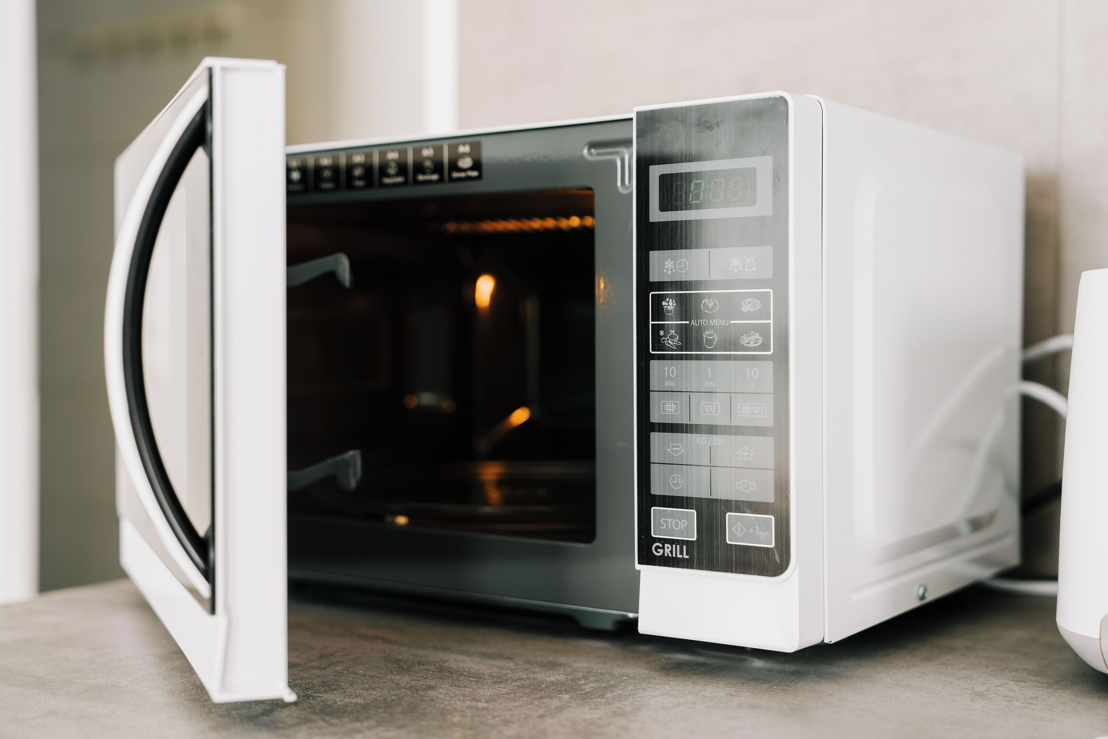 A white microwave oven with a digital display and various control buttons, including a grill function.